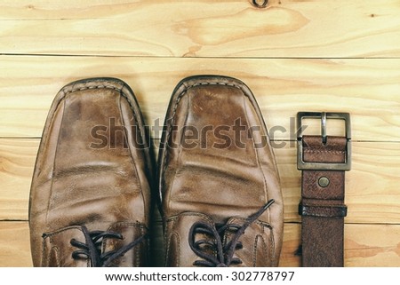 Brown leather men\'s shoes and belt on a wooden board. Men fashion. Men accessories. HDR.