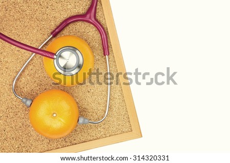 Stethoscope examining orange on a cork board. Medical equipment, Healthy food, Healthy eating concept. (Vintage Style Color)