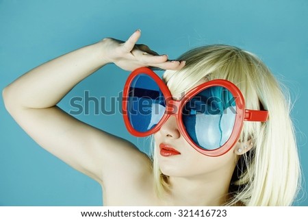 Funny girl with funny glasses, Happy naughty blonde hair woman with giant sunglasses. Woman in crazy clown glasses, Large funny glasses. Looking forward.(Vintage Style Color)