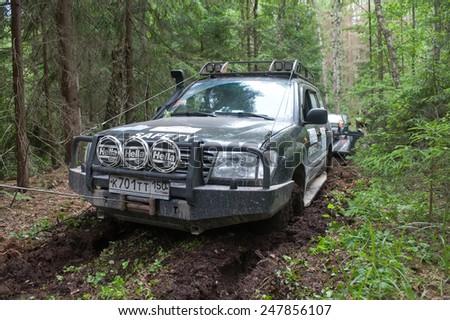 CHERNOGOLOVKA, MOSCOW REGION, RUSSIA - JUNE 21, 2013: Off-road vehicle Toyota Land Cruiser on a forest road, 3rd international meeting \