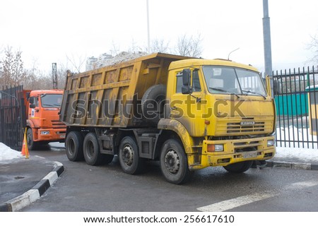 MOSCOW, RUSSIA - February 13, 2015: Yellow chetyrehosnyj dump trucks with snow enters into a snow melting point in Moscow