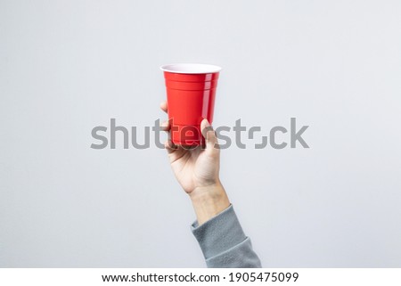 Similar – Image, Stock Photo Hand holding red cup with steaming drink against the light