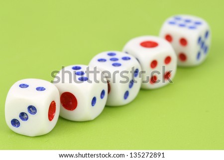 rolling dices with red and blue dots against green background