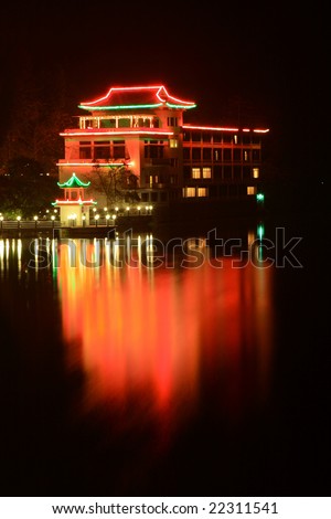 night scene of a chinese traditional building at river side