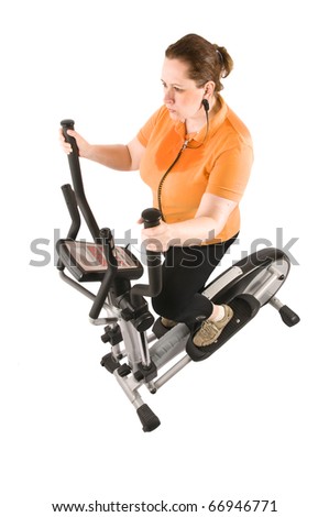 Obese adult woman with orange T-shirt and black pants make training with cross trainer in front of white background