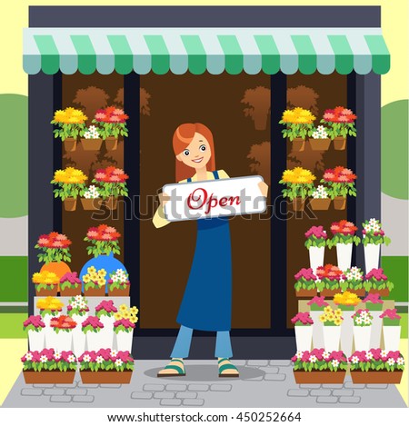 Florist holding open-sign while smiling in garden center