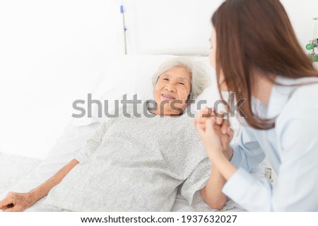 close up old people, old asian patient sick and admit in hospital, young asian female visiting old female, they holding hands together, they feeling happy and smile, elderly healthcare