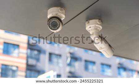 Similar – Image, Stock Photo Surveillance camera on a light pole behind a wall with barbed wire