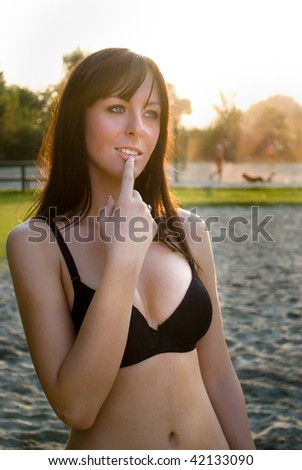 Girl in a bikini thinking with finger on her mouth