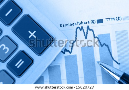 top-view of stock graph - focus is on graph with pen and calculator in foreground