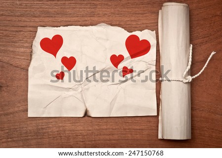 Red Hearts on ancient paper scroll on wooden table for Valentines Day