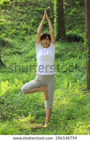 Japanese woman doing yoga tree pose
