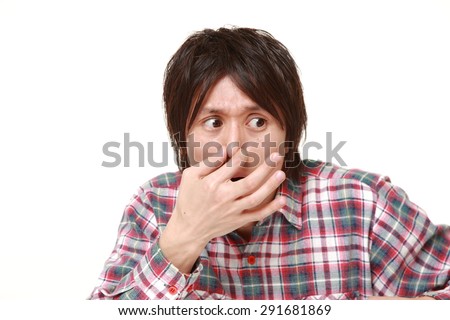 Japanese man holding his nose because of a bad smell
