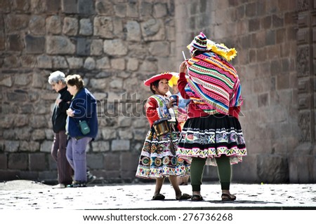 CUZCO, PERU, AUGUST 1 - Quechua Indians break from posing with tourists, drinking sodas - August 1, 2011 in Cuzco, Peru