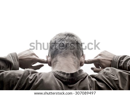 Young man turned back and has his fingers in his ears, against white background