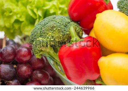 A lot of healthy colorful different vegetables and fruits - broccoli, paprika, lemon, salad and purple grapes