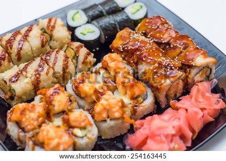 Assortment of delicious fresh, tempura and baked sushi maki with salmon, eel, cucumber, avocado, scrambled eggs, shrimp and unagi sauce