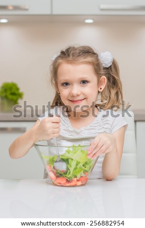 Little young cute sweet smiling girl make fresh healthy vegetable salad