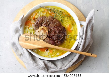 Traditional Russian Cabbage Soup Schi With Marrow Bone Broth On White Bowl With Napkin And Wooden Spoon On Round Board. Top View, Flat Lay. Imagine de stoc © 