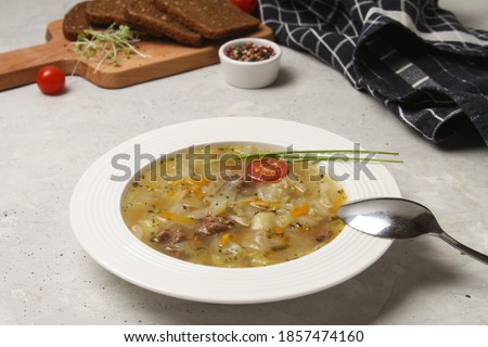 Traditional Cabbage Soup Schi On White Plate With Rye Bread, Napkin And Spoon On Grey Board. Side View. Imagine de stoc © 