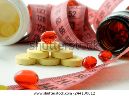 Measuring tape and bottle with pills. supplements for weight loss