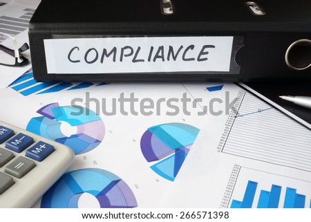 Graphs and file folder with label  Compliance . Business concept.