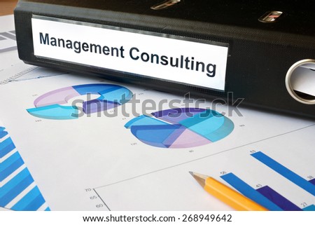 Graphs and file folder with label Management Consulting. Business concept.