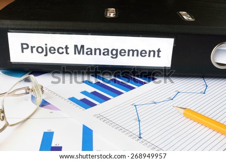 Graphs and file folder with label  Project Management. Business concept.
