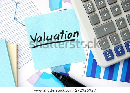 Papers with graphs, calculator and Valuation concept.