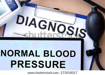 Tablet with  normal blood pressure, form with word diagnosis and blood pressure meter