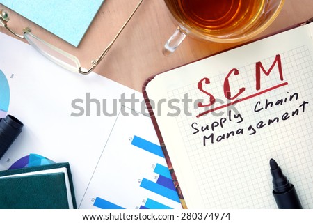 Notepad with words SCM supply chain management  concept and marker.