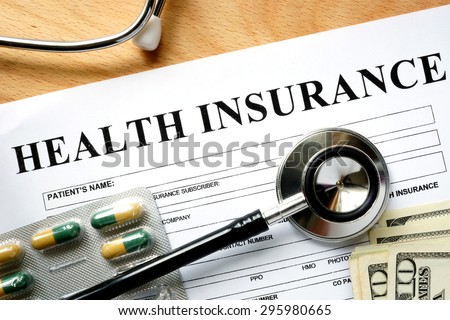 Health insurance form with stethoscope and pills.