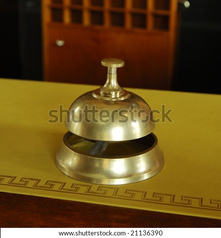 Service ring bell on a hotel desk reception - France - At the background the rooms keys cases