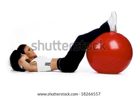 Brunette woman doing a sit up work out on a red fitness ball