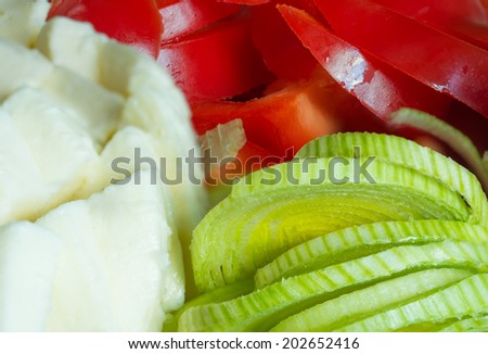 Sliced vegetables and cheese during a meal preparation