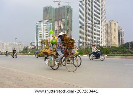 Hanoi, Vietnam - April 13, 2014: Traffic on Hanoi street with under construction buildings  on background. Hanoi Capital region will be a large synthetic economic region of nation and Asia