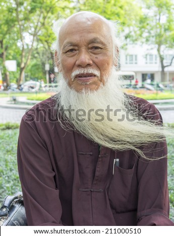 Hanoi, Vietnam - May 3, 2014: Portrait of an old man with long white beard sitting on park in Hanoi, Vietnam