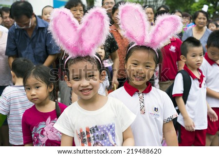 Hanoi, Vietnam - Sept 8, 2014: Children wearing rabbit hats at the show of lion dance at Times City complex on Vietnamese mid autumn festival day