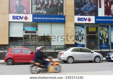 Hanoi, Vietnam - Nov 9, 2014: Vincom building in Ba Trieu street with bunch of BIDV bank logo. Cars packing on street side and motorbike running on street
