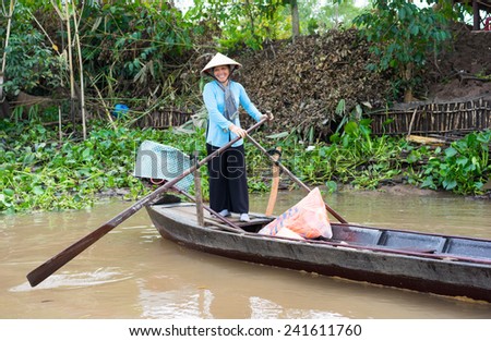 An Giang, Vietnam - Nov 29, 2014: Rural woman rows tourism boat in Tien river, Mekong delta, southern Vietnam. There are more and more tourists come to Mekong delta to enjoy the living in rivers
