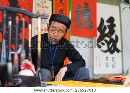 Hanoi, Vietnam - Feb 15, 2015: Vietnamese scholar at lunar new year calligraphy festival organizing at Temple of Literature Van Mieu