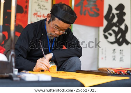 Hanoi, Vietnam - Feb 15, 2015: Vietnamese scholar at lunar new year calligraphy festival organizing at Temple of Literature Van Mieu