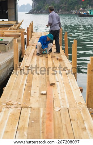 Quang Ninh, Vietnam - Mar 22, 2015: Vietnamese worker make wooden boat in Bai Tu Long bay, Ha Long city
