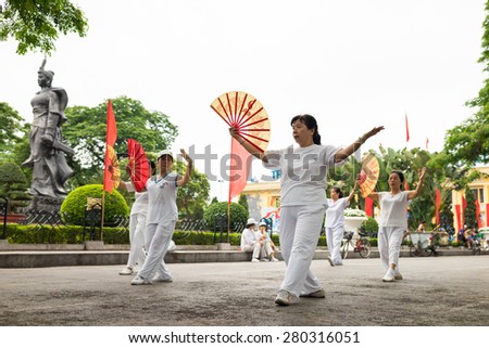 Haiphong, Vietnam - Apr 30, 2015: Group of Asian senior people training a dance with fan at center park of Haiphong