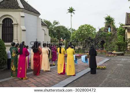 Ninh Binh, Vietnam - May 16, 2015: Vietnamese Christian women wearing traditional dress Ao Dai perform \