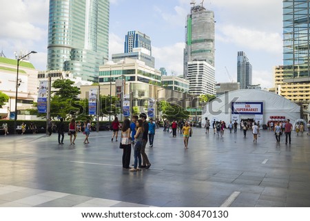 Bangkok, Thailand - June 29, 2015: People walking on spacious sidewalk in front of Central World building, Bangkok. High buildings on background