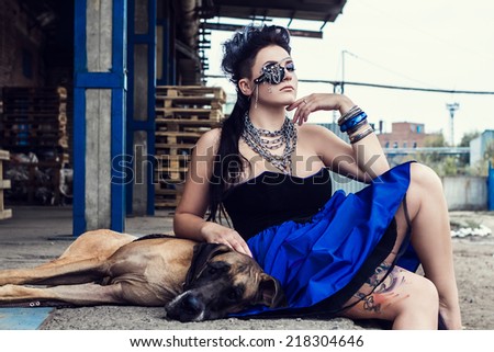 Fashion rocker style model girl portrait with dog in lush dress. Hairstyle. Rocker or Punk