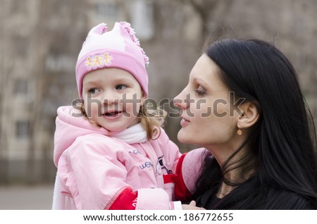 Little girl keeps mum on his hands. The girl thoughtfully laid her head on her mother\'s shoulder. A warm spring day.