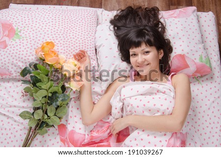 A beautiful young girl who lies in bed, gave flowers