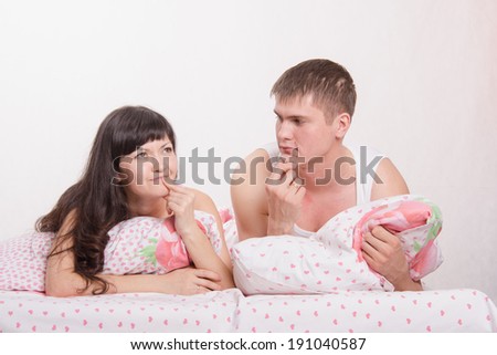 Young beautiful couple are thinking about the problems lying in bed